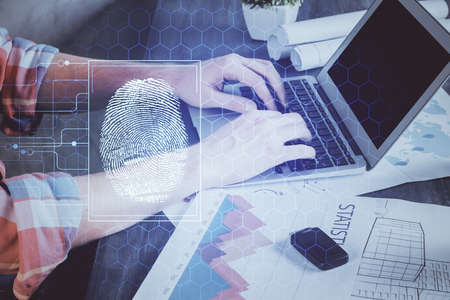 Fingerprint hologram with businessman working on computer on background. Security concept. Double...
