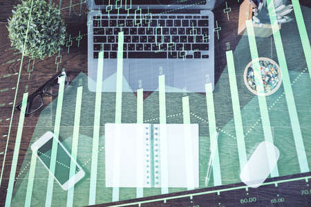 Stock market graph and top view computer on the table background. Double exposure. Concept of financial education.の写真素材