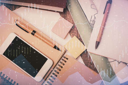 Multi exposure of forex graph hologram over desktop with phone. Top view. Mobile trade platform concept.の写真素材