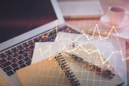 Double exposure of financial chart drawing and desktop with coffee and items on table background....