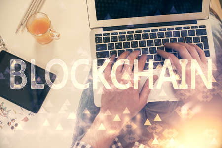 Double exposure of mans hands typing over computer keyboard and crypto currency theme hologram drawing. Top view. Blockchain concept.の写真素材