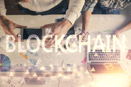Double exposure of man and woman working together and crypto theme hologram drawing. Computer background. Blockchain concept. Top View.の写真素材