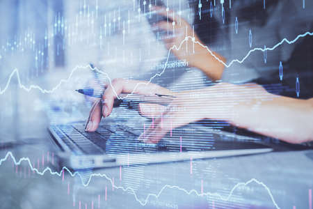 Multi exposure of woman hands typing on computer and financial graph hologram drawing. Stock market...