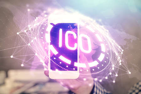 Double exposure of mans hands holding and using a phone and crypto currency blockchain theme...