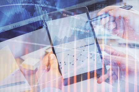 Double exposure of mans hands holding and using a phone and financial chart drawing. Market analysis concept.の写真素材