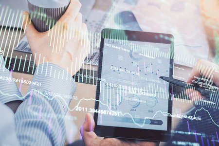 Double exposure of mans hands holding and using a phone and financial chart drawing. Market analysis...