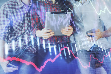 Double exposure of forex graph drawing and man and woman working together holding and using a mobile...