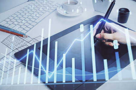 Double exposure of financial graph sketch hologram and woman holding and using a mobile device....