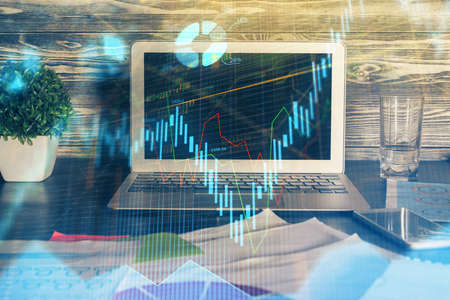 Double exposure of chart and financial info and work space with computer background. Concept of...