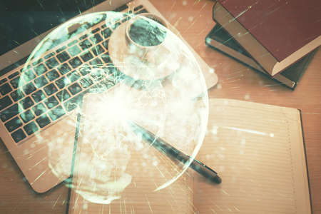 Business theme hologram drawings over computer on the desktop background. Top view. Multi exposure. Concept of international connections.の写真素材