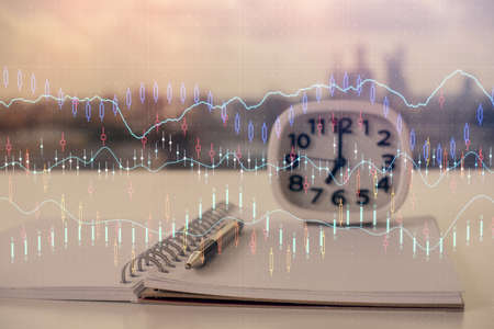 Double exposure of financial graph drawings and desk with open notebook background. Concept of forex...