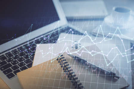 Double exposure of financial chart drawing and desktop with coffee and items on table background....