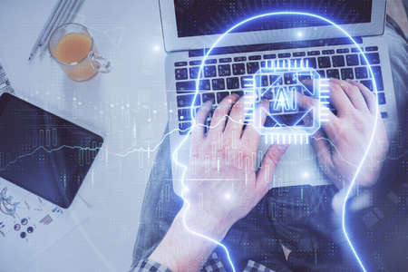 Double exposure of mans hands typing over computer keyboard and brain hologram drawing. Top view. Ai...