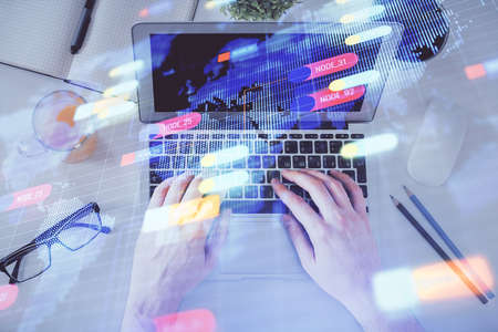 Multi exposure of mans hands typing over computer keyboard and data theme hologram drawing. Top...