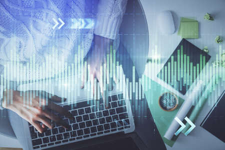 Multi exposure of woman hands working on computer and forex chart hologram drawing. Top View....