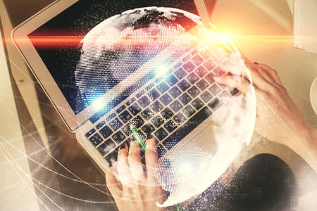 Double exposure of woman hands working on computer and financial theme hologram drawing. Top View. Business concept.の写真素材