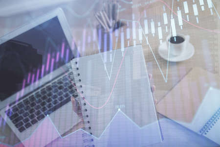 Double exposure of businesswoman hands typing on computer and forex chart hologram drawing....