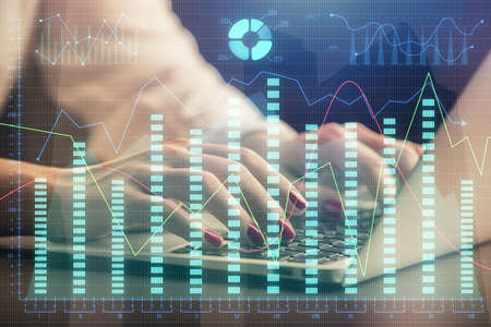 Double exposure of businesswoman hands typing on computer and forex chart hologram drawing....
