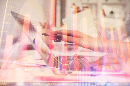Multi exposure of woman hands typing on computer and financial graph hologram drawing. Stock market...