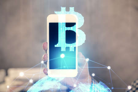 Double exposure of mans hands holding and using a phone and crypto currency blockchain theme drawing.の写真素材
