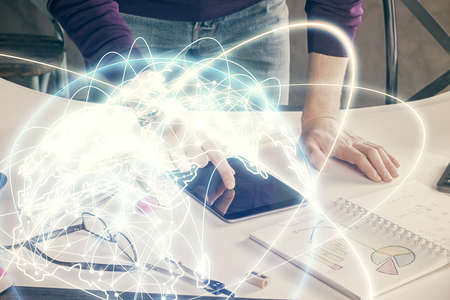 Double exposure of mans hands holding and using a phone and international business theme drawing.