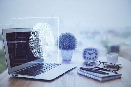 Computer on desktop in office with finger print drawing. Double exposure. Concept of business data security.の写真素材