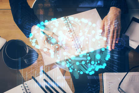 Double exposure of writing hand on background with brain hologram. Concept of learning.の写真素材