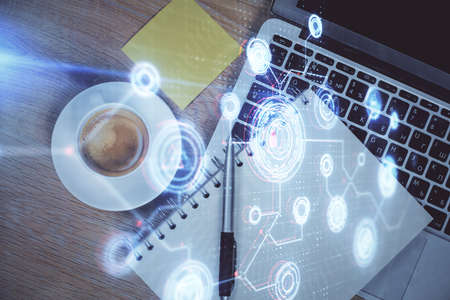 Double exposure of data drawing hologram over topview of study desk background with computer....
