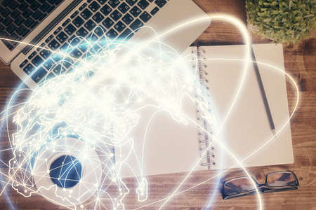 Business theme hologram drawings over computer on the desktop background. Top view. Multi exposure....