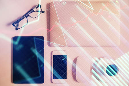 Multi exposure of financial chart hologram over desktop with phone. Top view. Mobile trade platform...