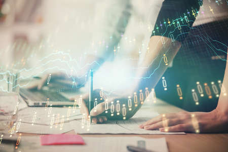 Multi exposure of woman hands typing on computer and financial chart hologram drawing. Stock market...