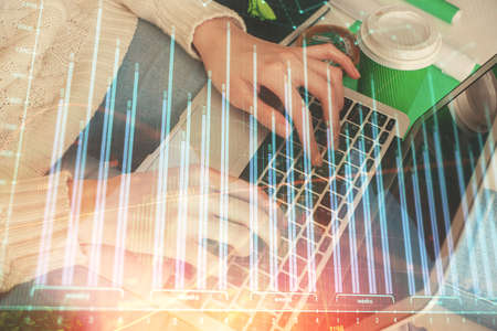 Double exposure of woman hands typing on computer and forex chart hologram drawing. Stock market invest concept.の写真素材