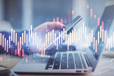 Double exposure of mans hands holding and using a phone and financial graph drawing. Analysis...