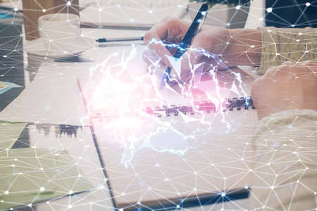 Double exposure of writing hand on background with brain hologram. Concept of learning.