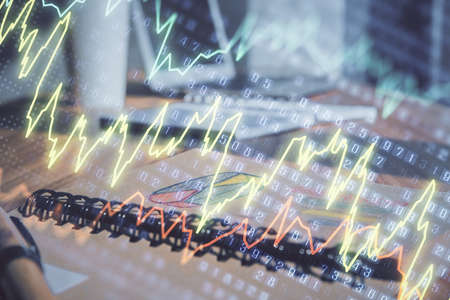 Double exposure of financial graph drawings and desk with open notebook background. Concept of forex...