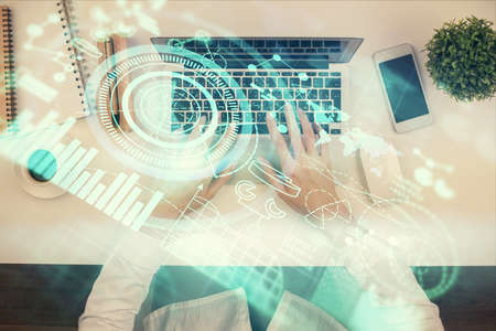 Double exposure of woman hands working on computer and financial theme hologram drawing. Top View....