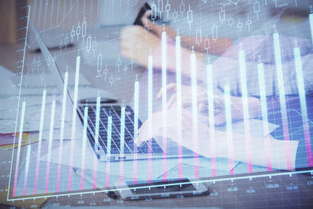 Multi exposure of woman hands typing on computer and financial chart hologram drawing. Stock market...
