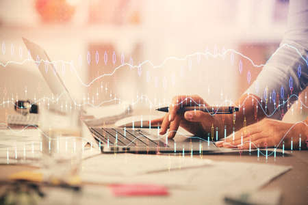 Double exposure of woman hands typing on computer and forex chart hologram drawing. Stock market...
