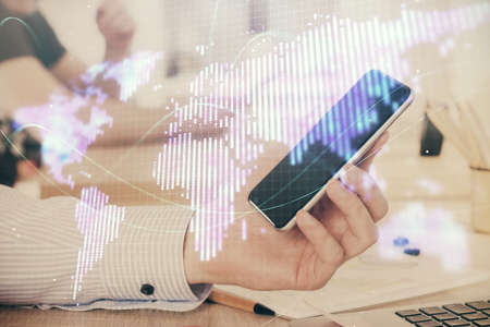 Double exposure of mans hands holding and using a phone and international business theme drawing.