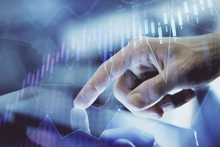 Multi exposure of mans hands holding and using a digital phone and forex graph drawing. Financial...