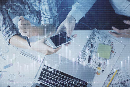 Double exposure of forex graph drawing and man and woman working together holding and using a mobile...