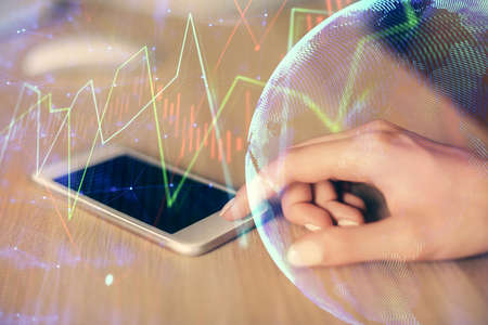 Double exposure of forex chart sketch hologram and woman holding and using a mobile device....