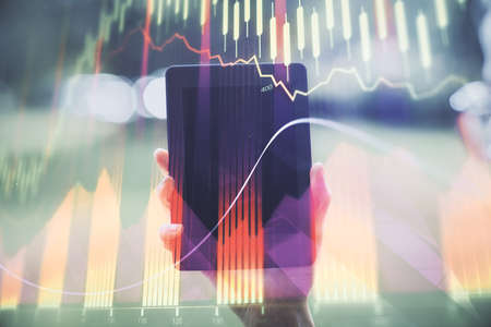 Double exposure of forex chart sketch hologram and woman holding and using a mobile device....