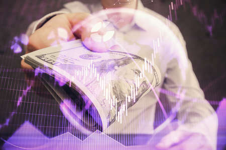 Multi exposure of financial graph drawing hologram and USA dollars bills and man hands. Analysis...
