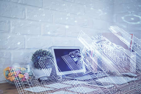Desktop computer background in office and big town buildings hologram drawing. Double exposure....