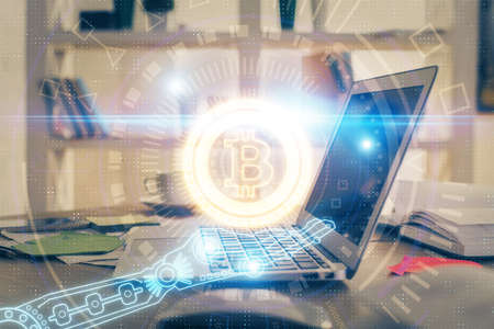 Multi exposure of blockchain theme hologram and table with computer background. Concept of bitcoin...