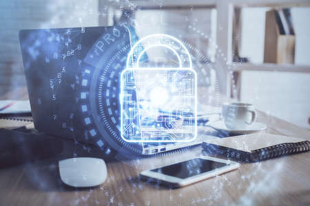 Double exposure of desktop with computer and lock icon hologram. Concept of data safety.