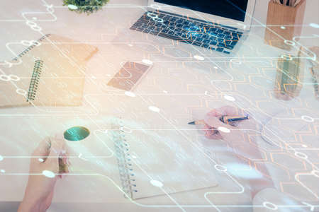 Double exposure of writing hand on background with data technology hologram. Big data concept.