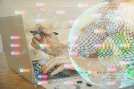 Multi exposure of world map hologram with man working on computer on background. Concept of...