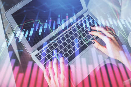 Double exposure of woman hands working on computer and forex chart hologram drawing. Top View....